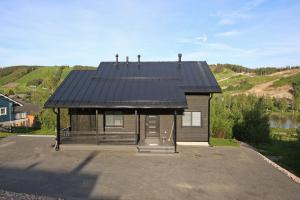 a small house with a black roof on a driveway at Amiraali in Jämsä