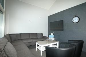 a living room with a couch and a clock on a wall at Amiraali in Jämsä