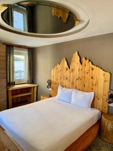 een slaapkamer met een groot bed met een houten hoofdeinde bij Cesa Balzan in Canazei