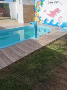 una piscina in un cortile con un muro di dinosauri di Casa Morato a Mata de Sao Joao
