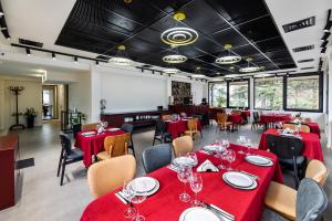 Un comedor con mesas y sillas rojas. en Nouvelle Hotel, en Oni