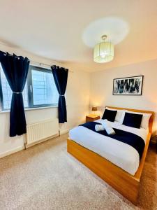 een slaapkamer met een groot bed en twee ramen bij Scotapartments in Edinburgh