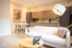 a living room with a white couch and a table at 10 Park Square East, Luxury Serviced Apartments in Leeds