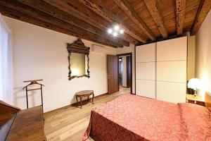 um quarto com uma cama e um espelho na parede em Mercerie e Capitello Apartments em Veneza