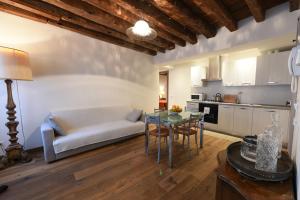 uma sala de estar com um sofá e uma mesa em Mercerie e Capitello Apartments em Veneza