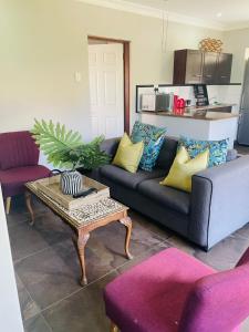 5 OYSTER COTTAGE في ديربان: غرفة معيشة بها أريكة وطاولة