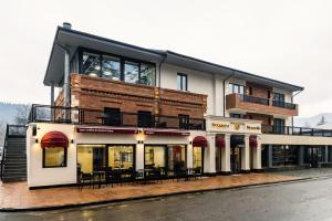 Un edificio con mesas y sillas delante. en Nouvelle Hotel, en Oni