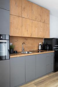 a kitchen with a sink and a refrigerator at ADLER CHILL Apartments in Łódź