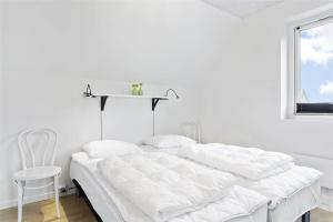 a white bedroom with a bed and a chair at 793-Thisted-Havstokken-24-1 in Thisted