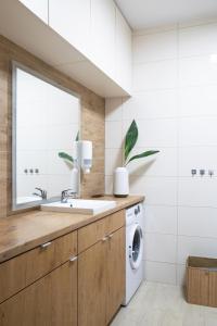 a bathroom with a sink and a washing machine at ADLER CHILL Apartments in Łódź