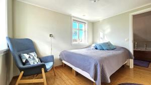 a bedroom with a bed and a chair and a window at Family-friendly house close to sea & nature in Klövedal SE09145 in Viks Ödegärde