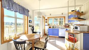 a kitchen with a wooden table and blue cabinets at Family-friendly house close to sea & nature in Klövedal SE09145 in Viks Ödegärde