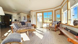 a living room with couches and a table and windows at Family-friendly house close to sea & nature in Klövedal SE09145 in Viks Ödegärde