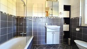 a bathroom with a sink and a tub and a toilet at Family-friendly house close to sea & nature in Klövedal SE09145 in Viks Ödegärde +24 photos