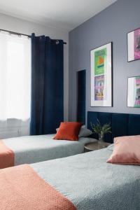 two beds in a room with blue and orange at ADLER CHILL Apartments in Łódź