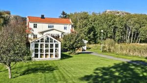a large house with a yard with a large window at Family-friendly house close to sea & nature in Klövedal SE09145 in Viks Ödegärde