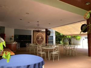 a restaurant with tables and chairs and a sign at Tarik Fontes Plaza Hotel in Itabuna