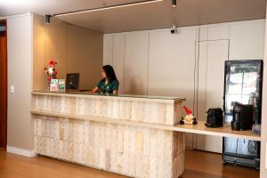 una mujer sentada en un mostrador en una oficina en Oasis Hotel, en Cajazeiras 40 fotos más