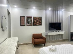 a room with a bed and a chair and a television at Khách sạn Sole'a VĨNH YÊN in Vĩnh Phúc