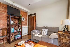 Una sala de estar con un sofá y una pared de ladrillos. en La Piñera, pola de Siero, en Siero