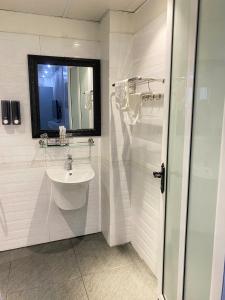 a white bathroom with a sink and a mirror at Khách sạn Sole'a VĨNH YÊN in Vĩnh Phúc