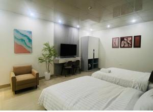 a bedroom with two beds and a desk and a television at Khách sạn Sole'a VĨNH YÊN in Vĩnh Phúc