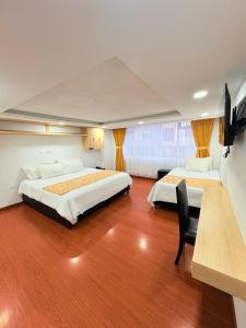 a bedroom with two beds and a chair in it at Hotel Lagos Latin America in Pasto