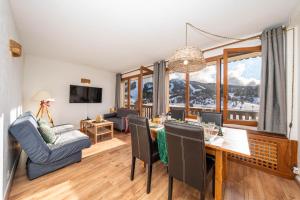 Una televisión o centro de entretenimiento en Panorama des Cimes - T3 avec Sauna privé et Vue imprenable sur la Station