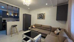 a living room with a couch and a kitchen at T2 Cosy & Central Akid Lotfi in Oran