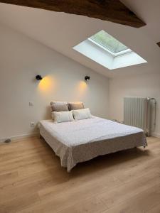 a bedroom with a bed and a skylight at Au plaisir de l'ivoie in Le May-sur-Èvre +8 photos