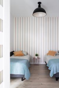 a bedroom with two beds and a pendant light at ADLER Room Suite in Łódź