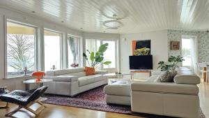 Wonderful villa with panoramic sea view SE09144 في Krommeröd: غرفة معيشة مع أريكتين وتلفزيون