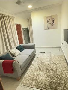 a living room with a couch and a table at Cozy Apartment in Kololi