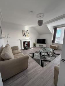 Casa Fresa - 31B High Street في Monifieth: غرفة معيشة مع أريكة وطاولة زجاجية