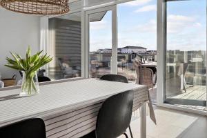 Una mesa de comedor con sillas y una gran ventana. en 1302-Thisted-Havstokken-30-1, en Thisted 17 fotos más