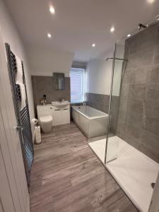 Casa Fresa - 31B High Street في Monifieth: حمام مع دش وحوض استحمام ومغسلة