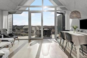 Una sala de estar con una mesa y sillas y una gran ventana. en 1302-Thisted-Havstokken-30-1, en Thisted