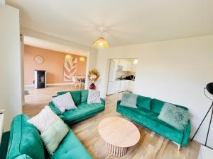 Beaussais sur MerMaison familiale centre ville的客厅配有绿色沙发和桌子