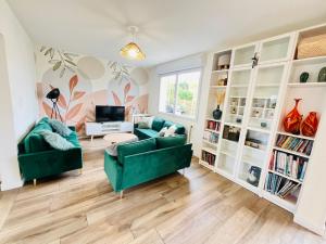 Beaussais sur MerMaison familiale centre ville的客厅里有一张绿色的沙发和一张桌子