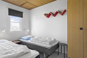 a room with two beds and books on the wall at 212-Vestervig-Havnevej-1-lejl-12 in Vestervig +27 photos