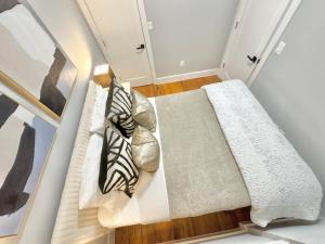 a bed in a room with two pillows at Dream Home Close to the Center of NYC in Mott Haven