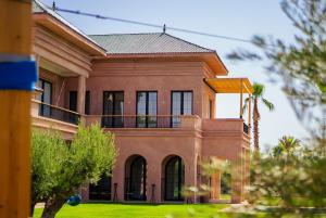a large brick house with a balcony on a lawn at Villa Jumeirah M Luxury & Spacious Pool in Marrakech +52 photos