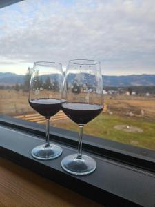 two glasses of wine sitting on a window sill at La Cuiburi in Sărişor