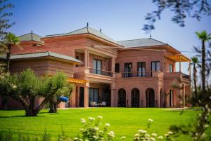 a large house with a green lawn in front of it at Villa Jumeirah M Luxury & Spacious Pool in Marrakech