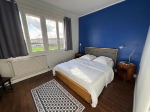 ein Schlafzimmer mit einem großen Bett mit einer blauen Wand in der Unterkunft Villa Simone - 8 pers, 100m plage et sauna in Mers-les-Bains