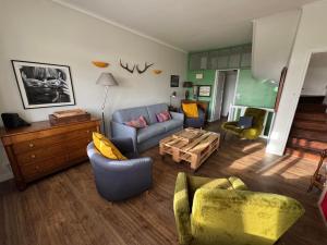 ein Wohnzimmer mit Sofa, Stühlen und einem Tisch in der Unterkunft Villa Simone - 8 pers, 100m plage et sauna in Mers-les-Bains