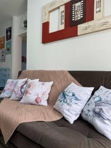 a couch with three pillows on top of it at Minha Casa Palmas 2 in Governador Celso Ramos +19 photos