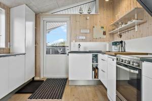 a kitchen with white appliances and a door to a balcony at 1059-Klitmoller-Mollebakken-56 in Klitmøller