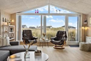 a living room with two chairs and a large window at 1059-Klitmoller-Mollebakken-56 in Klitmøller