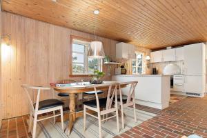 a kitchen with a wooden ceiling and a table and chairs at 930-Thisted-Liusborg-Sti-28 in Torsted
